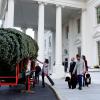 First Lady Michelle Obama, with daughters Sasha and Malia and family pets Bo and Sunny, receives the official White House Christmas tree at the North Portico of the White House, November 28, 2014.