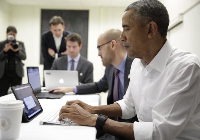 President Barack Obama typing on a tablet participating in a Twitter Q&A at McKinley High School in Baton Rouge, La.
